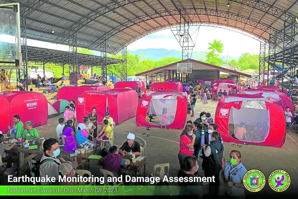 Officials of the health and social welfare departments on Wednesday check on the families who evacuated from their quake-affected homes in Nabunturan, Davao de Oro