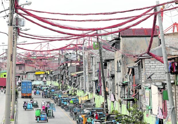 Electrical lines stretching over and in between houses of informal settlers in Barangay 20, Parola, Tondo. An additional subsidy is being proposed to help them cope with higher inflation. STORY: P418-million power subsidy for poor families sought      