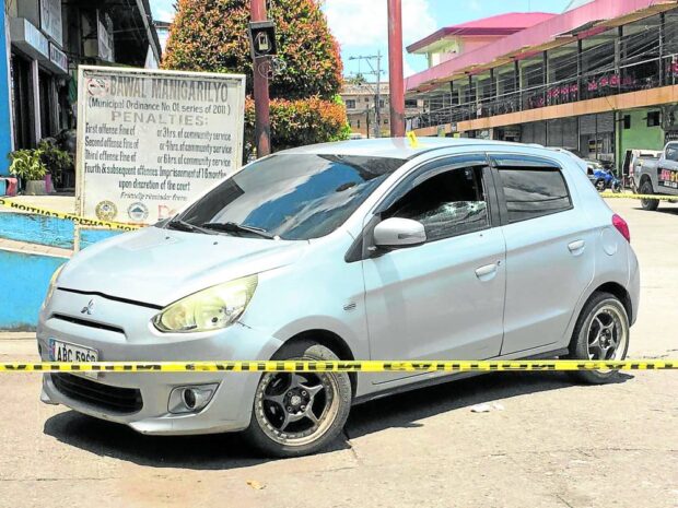 A police line surrounds the bullet-riddled car of Rhyolite Agregado Balili, a former town councilor and now aide of Polomolok Mayor Bernie Palencia, STORY: South Cotabato mayor offers P500,000 reward for info on aide’s attackers