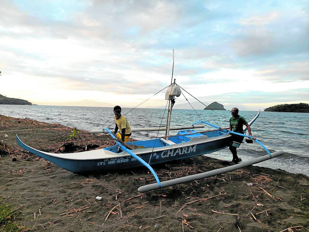 Fishermen in the village of Suqui in the Oriental Mindoro capital city of Calapan take a boat to shore as they have to wait for the lifting of a fishing ban prompted by the oil spill from a fuel tanker that sank off Naujan town on Feb. 28. 