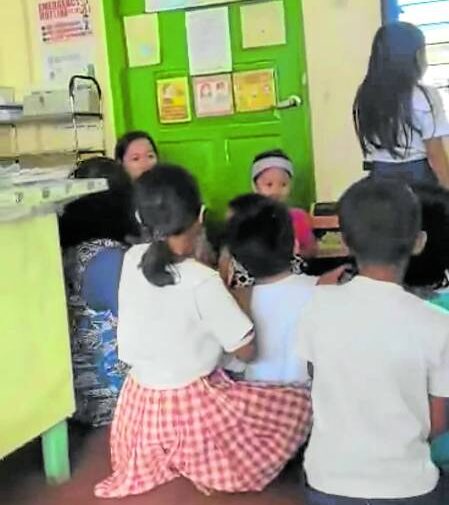  In this photo taken on Wednesday, students in an elementary school in Placer, Masbate, duck and seek safe spaces in their classrooms as fighting between governmentsoldiers and NewPeople’s Army rebels break out