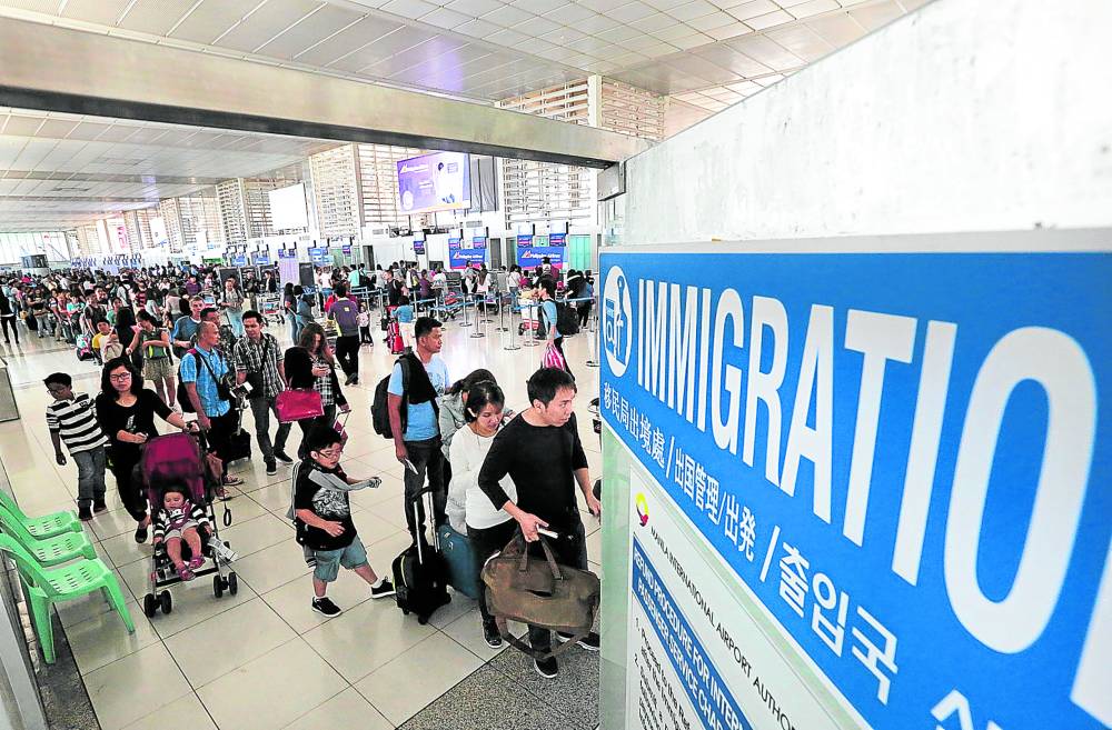 Departing passengers line up at the immigration counters of the Ninoy Aquino International Airport (Naia) prior to boarding their respective flights in this 2017 file photo