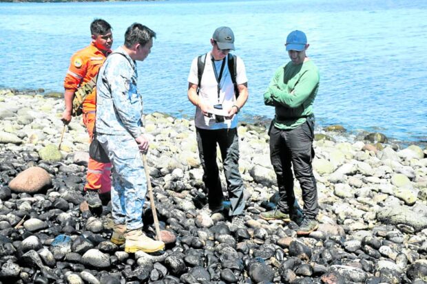 INSPECTION   French experts have joined a team from the Philippine Coast Guard (PCG) in testing water samples gathered from the shoreline of Pola town in Oriental Mindoro to measure the level of oil contamination from sunken tanker MT Princess Empress, in this photo posted on the PCG Facebook 
on March 26. —PHOTO COURTESY OF PCG
