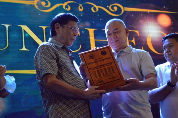Former President Rodrigo Duterte receives a plaque from Cagayan de Oro City Mayor Rolando Uy as an adopted son of the city. STORY: Cagayan de Oro declares Duterte, Go as ‘adopted sons’