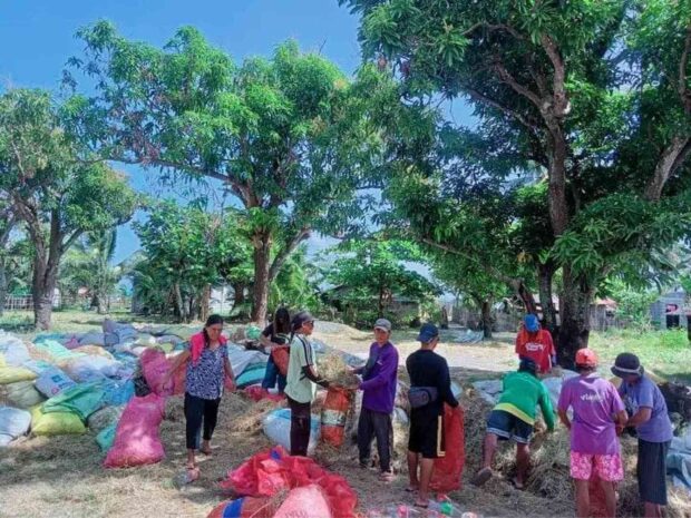 Residents of the coastal village of Navotas in Calapan City in Oriental Mindoro province work together on March 15 to make improvised oil spill booms to protect their shores from the oil spill coming from a fuel tanker that sank off Naujan town on Feb. 28, 2023. STORY: More Calapan areas seen to be hit by oil spill