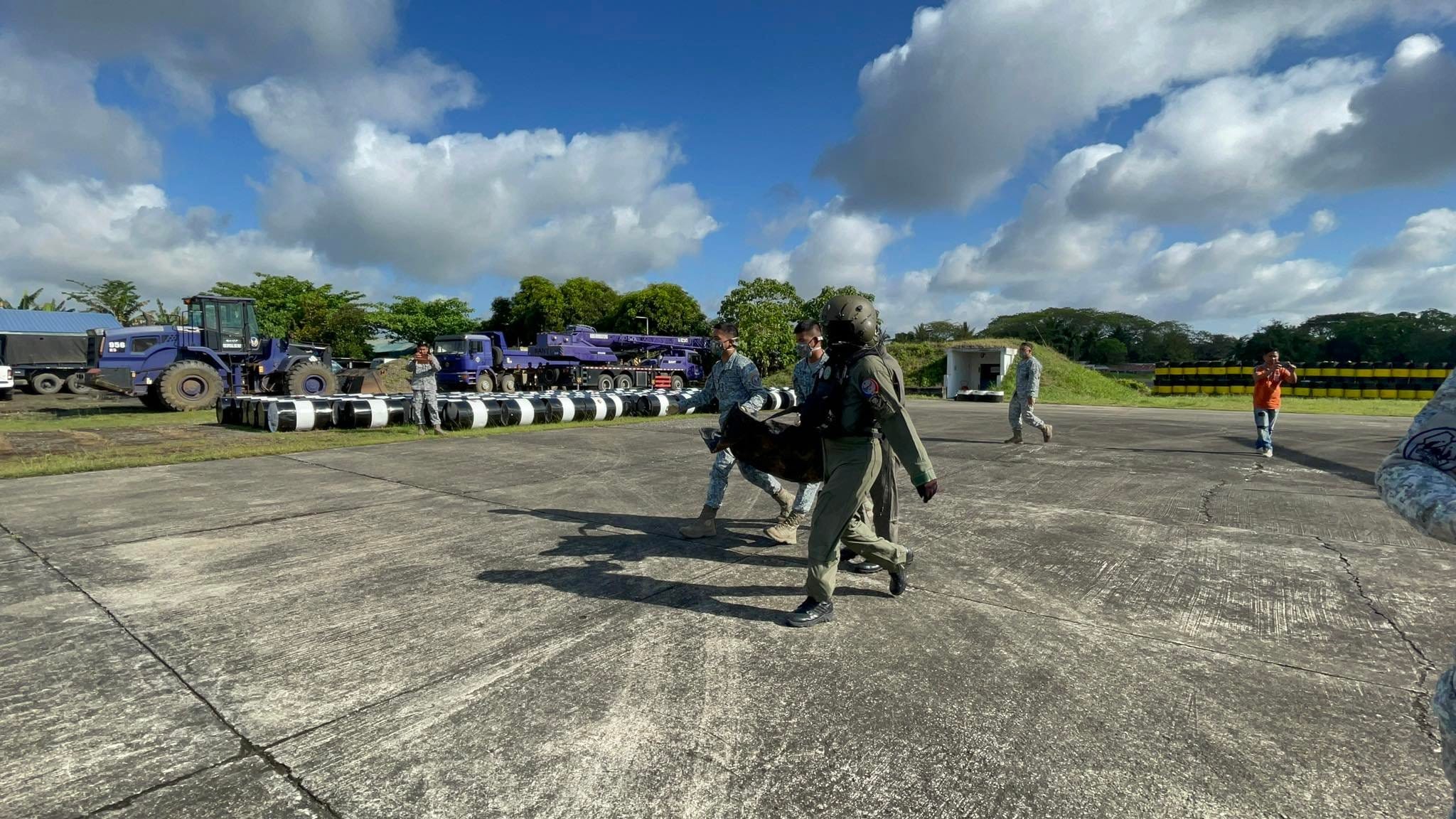 Air Force-Tactical Operations Group 2 crew members carry the remains of the victims who died in a plane crash in Isabela province