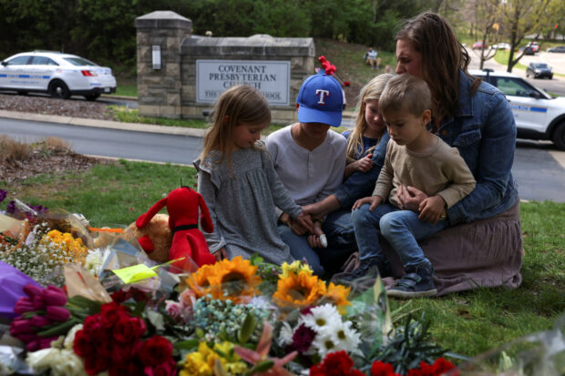 Emily Ryan and her children pray at a memorial at the school entrance after a deadly shooting at The Covenant School in Nashville, Tennessee, U.S., March 28, 2023. REUTERS/Austin Anthony