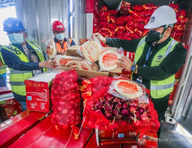 The Bureau of Customs intercepted 18 containers declared to have pizza dough and fishballs inside, but turned out to be red and yellow onions instead.  This is the latest in a series of raids conducted by the BOC in relation to onion and agricultural smuggling.  (Photo from the Bureau of Customs)