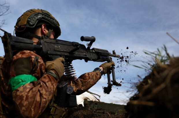 Ukrainian service member, Naza, 21, commander from 28th mechanised brigade repositions his machine gun during a fire exchange at the front line, in the region of Bakhmut, Ukraine, April 5, 2023.  REUTERS/Kai Pfaffenbach