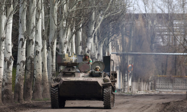 An armoured military vehicle speeds through Chasiv Yar during heavy fighting at the fronttline of Bakhmut and Chasiv Yar, Ukraine, April 9, 2023.  REUTERS/Kai Pfaffenbach