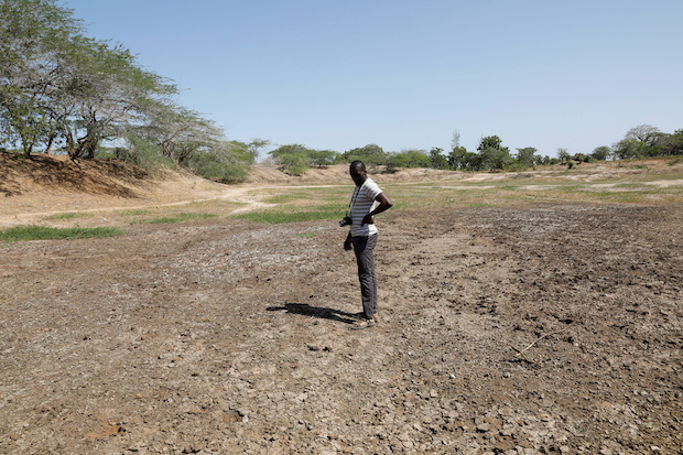 FEWS NET scientist Chris Shitote examines a dry water hole in Kilifi county. STORY: Africa needs more help with climate change, debt, food crisis
