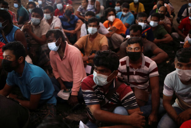 Migrant workers gather at the compound of their dormitory for a document check in Kuala Lumpur