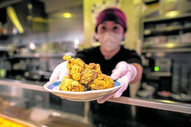 ‘JAPAN’S COMFORT FOOD’ A cook serving a plate of Japanese-style fried chicken “karaage” at a bar in Tokyo. 