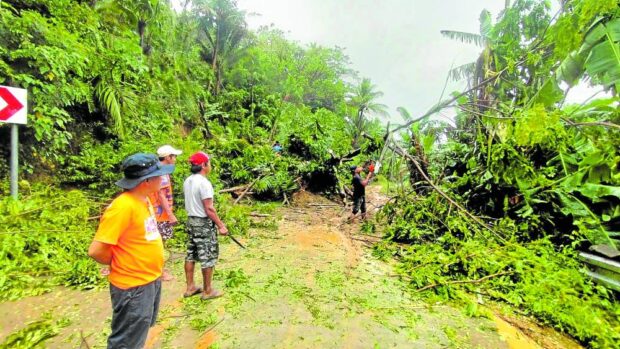 Emergency responders remove debris from a landslide that covered both lanes in Inoyonan–Itagon Road in Barangay Inoyonan in Bula town in Camarines Sur. STORY: Amang damage to agriculture reaches P50 million