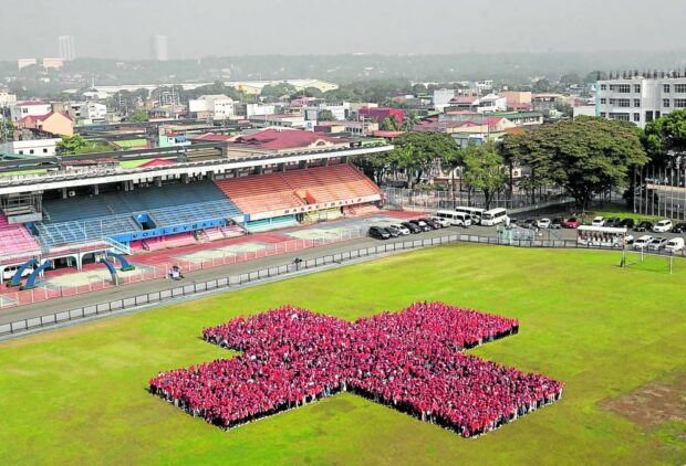 Volunteers of the Philippine Red Cross form its symbol at Marikina Sports Center on Saturday in one of the activities marking the 75th anniversary of the humanitarian organization,whose services, resources and reach continue to expand, and aptly so, in a country highly vulnerable to disasters, natural or otherwise. STORY: PH Red Cross at 75: Set for more challenges amid climate change