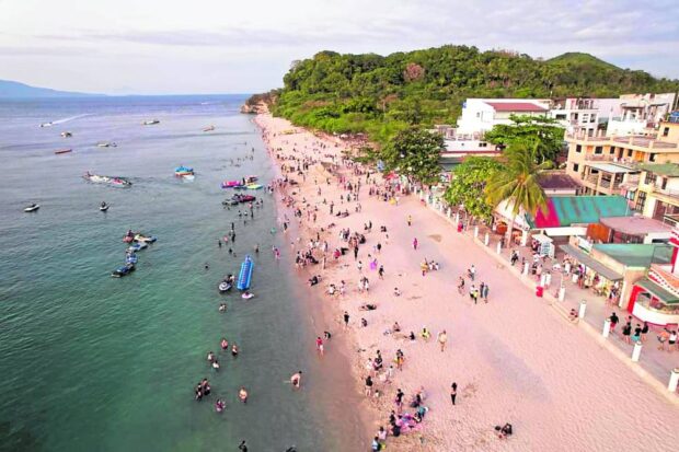 Puerto Galera’s famous White Beach plays host to hundreds of tourists enjoying the sun and sand in this photo taken on March 29, 2023. STORY: Despite poor water quality, Puerto Galera to stay open