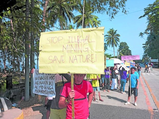 Residents of Sta. Catalina, Negros Oriental, armed with handmade posters including one that says "save nature," declare their objection to the ongoing mining exploration in Sitio Tarog, Barangay San Francisco of the town in a protest rally on April 12, 2023. STORY: Local execs, residents buck gold mine exploration in Negros Oriental town