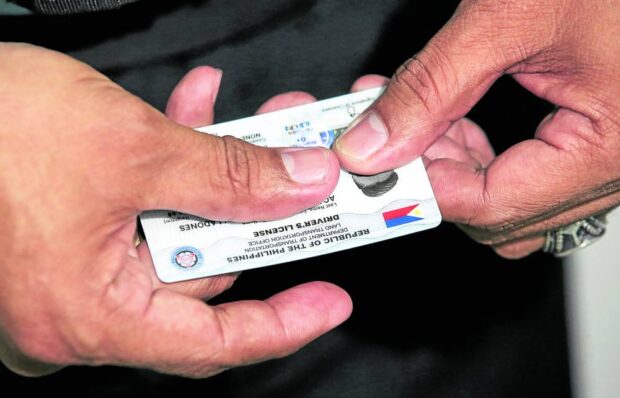 An LTO staff showing a brand new student driver's license at the Land Transportation Office Quezon City District Office in Centris Station.  card shortage motorist