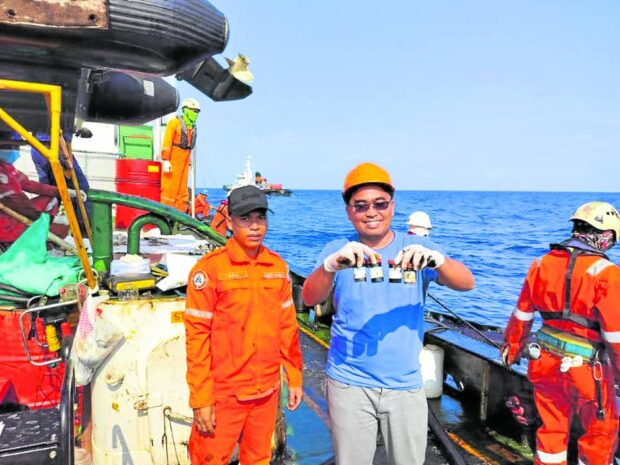 Scientist Hernando Bacosa (in blue shirt) and a member of the Philippine Coast Guard show samples gathered from shorelines that may have been affected by the oil spill from the sunken motor tanker MT Princess Empress. STORY: ‘Chemical fingerprinting’ of oil spill to help fisherfolk seeking damages