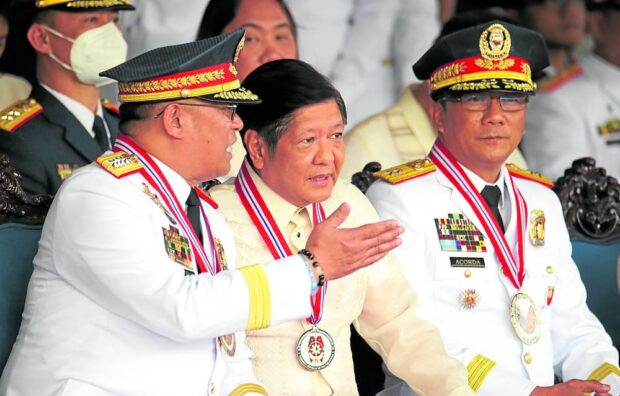 LEADERSHIP CHANGE President Marcos talks to outgoing Philippine National Police chief Gen. Rodolfo Azurin Jr. (left) during the turnover of command to Maj. Gen. Benjamin Acorda Jr. (right) at Camp Crame on Monday. —NIÑO JESUS ORBETA 