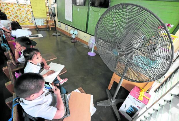 PHOTO: Students in a classroom with several electric fans. STORY: Teachers' group asks DepEd to implement measures vs heat