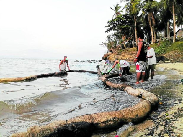 Villagers in Calapan City, Oriental Mindoro collect the oil spill from sunken MT Princess Empress using indigenous booms made of coconut husks, fishnets and jute sacks in an effort to protect their coastal resources in this photo taken on April 1, 2023. STORY: 