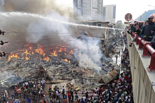 Firefighters try to extinguish a fire that broke out in a clothing market in Dhaka on April 4, 2023. Hundreds of firefighters were battling an immense blaze in the Bangladeshi capital on April 4 as an inferno raged through a popular clothing market, blanketing the city's oldest neighborhoods in black smoke. (Photo by AFP)