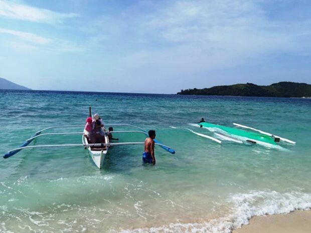 The motorbanca (right) capsized within the vicinity waters off Bonbon Beach in Romblon.