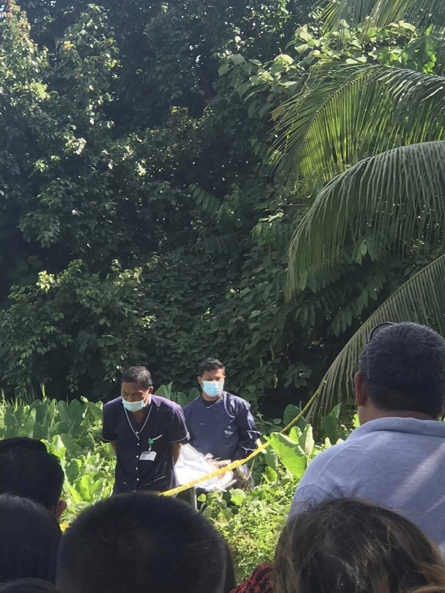 Health workers move the body of Nike Andyriana Kassim