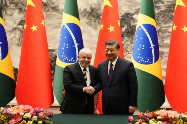 Chinese President Xi Jinping (R) and Brazil's President Luiz Inacio Lula da Silva shake hands after a signing ceremony at the Great Hall of the People in Beijing on April 14, 2023. (Photo by Ken Ishii / POOL / AFP)