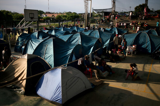 FILE PHOTO: Venezuelan migrants are seen inside a coliseum where a temporary camp has been set up, after fleeing their country due to military operations, according to the Colombian migration agency, in Arauquita