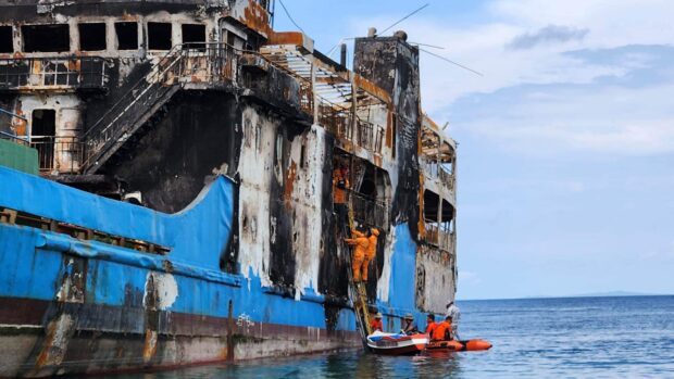 Investigators from the Bureau of Fire Protection (BFP) on Monday inspect what remains of MV Lady Mary Joy 3, which ran aground off Baluk-Baluk Island, Basilan, after it caught fire just before midnight on March 29, 2023. They are looking at faulty wiring as a possible cause of the blaze. STORY: Ferry fire victims’ kin protest end of search