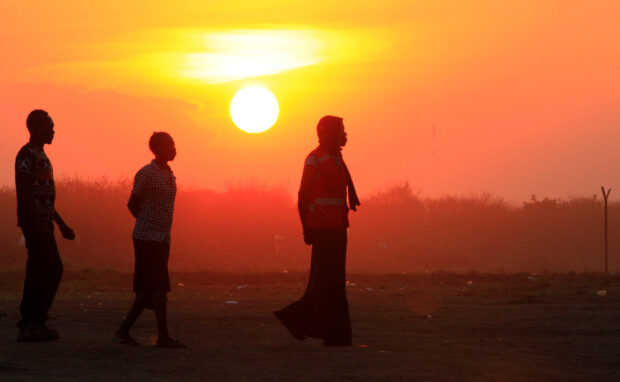 FILE PHOTO: People who fled fighting in South Sudan are seen walking at sunset on arrival at Bidi Bidi refugee’s resettlement camp near the border with South Sudan, in Yumbe district
