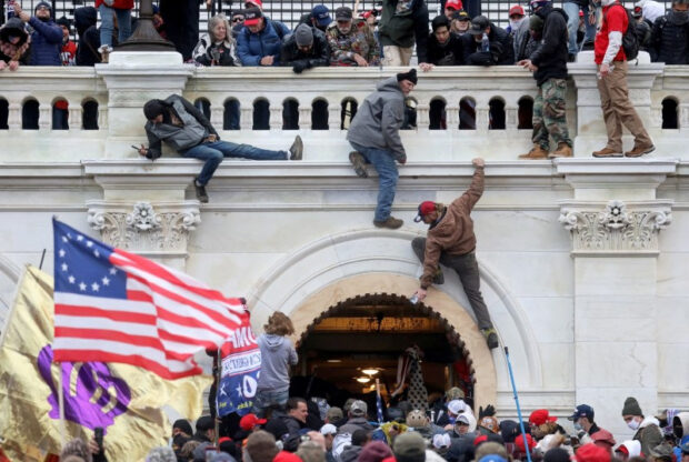 A mob of supporters of U.S. President Donald Trump fight with members of law enforcement at a door they broke open as they storm the U.S. Capitol Building in Washington, U.S., January 6, 2021. Picture taken January 6, 2021. REUTERS/Leah Millis/File Photo
