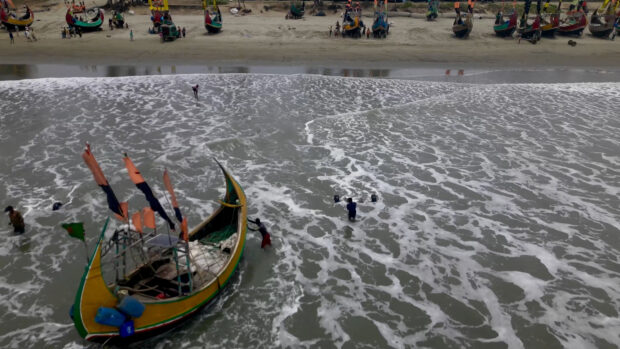 Storm surges whipped up by a powerful cyclone moving inland from the Bay of Bengal inundated the Myanmar port city of Sittwe but largely spared a densely-populated cluster of refugee camps in low-lying neighboring Bangladesh.