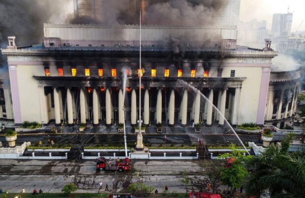 Firefighters douse a fire at the Post Office building in Manila on May 22, 2023. 