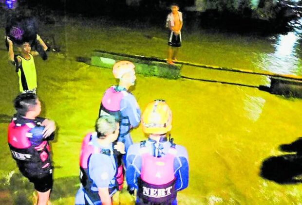 RESCUE WORK Personnel from the Nabunturan Emergency Response Team wade through flooded communities to move residents to safer grounds following the heavy rains in Nabunturan, Davao de Oro, over the weekend. PHOTO COURTESY OF NABUNTURAN MUNICIPAL GOVERNMENT 