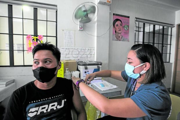 JAB FOR WORK A resident of Pasig City receives his first dose of COVID-19 vaccine at Rosario Super Health Center on Monday. He says he finally decided to get vaccinated due to work requirements. —LYN RILLON