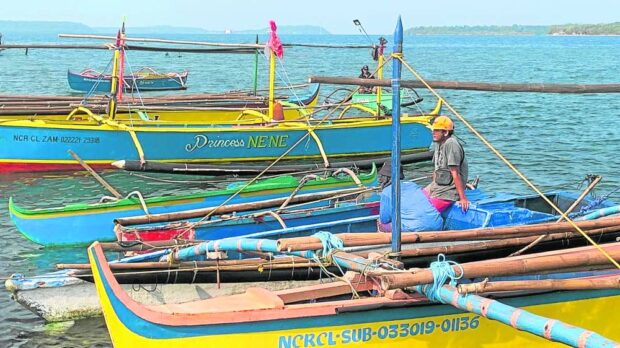 Fishermen in Masinloc, Zambales, take a break, in this photo taken on April 26, when a ban on sailing was enforced during the war games between the Philippines and the United States. On Thursday, local fishers heading to sea are again cautioned against debris falling from a rocket launched by China on Wednesday. 