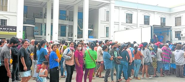 People wait in line to buy five kilos of rice, sold at P20 a kilo, during the Mercado Kidapaweño held in front of the Kidapawan City Hall on May 13. STORY: In Kidapawan, residents can buy rice at P20 a kilo from gov’t outlet