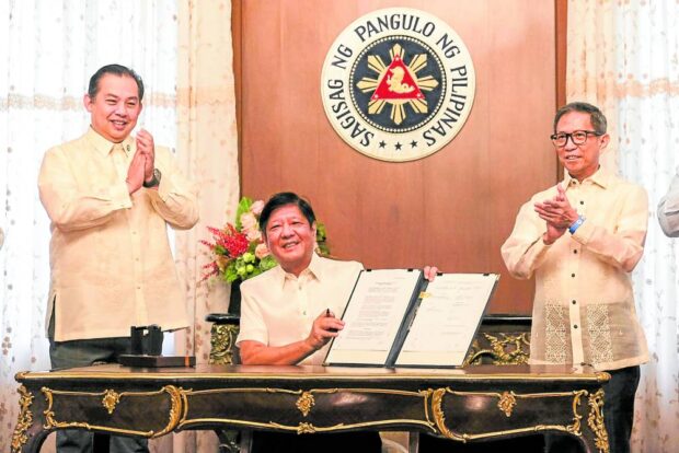 President Ferdinand Marcos Jr. signs the agreement extending the Malampaya Service Contract No. 38 on Monday. Among those who witnessed the signing are House Speaker Martin Romualdez (left) and Energy Secretary Raphael Lotilla. —MALACAÑANG PHOTO