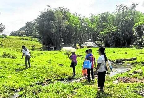 Health workers cross a small stream amid the heat to bring vaccines to households in a remote community in Zamboanga Peninsula region. STORY: Sweltering heat slows down vax drive in West Mindanao