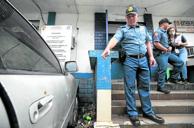 Col. Ruben Lacuesta, the Caloocan City police chief, points to one of the vehicles damaged by the strafing and grenade attack that targeted a Northern Police District office in Caloocan in the wee hours of Saturday. STORY: Attack on NPD post tied to drug busts, and it was not the first