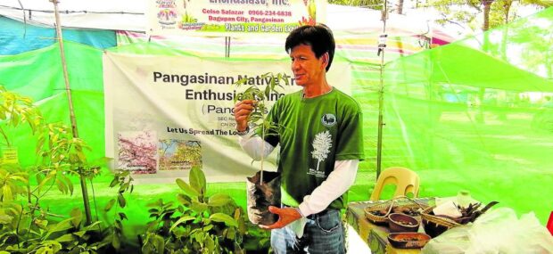 RAISINGAWARENESS Celso Salazar, president of the Pangasinan Native Tree Enthusiasts(PNTE), introduces rare native tree seedlings to passersby during the tourism-trade expo, one of the events held during the “Pista’y Dayat” (sea festival) celebration in the province last month. Salazar says PNTE is trying to instill love for native trees in Pangasinenses.