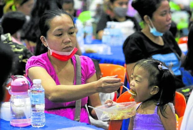 A child is fed snacks before getting a complete meal of rice, meat and vegetables during a food program. STORY: Businessmen join drive vs child malnutrition