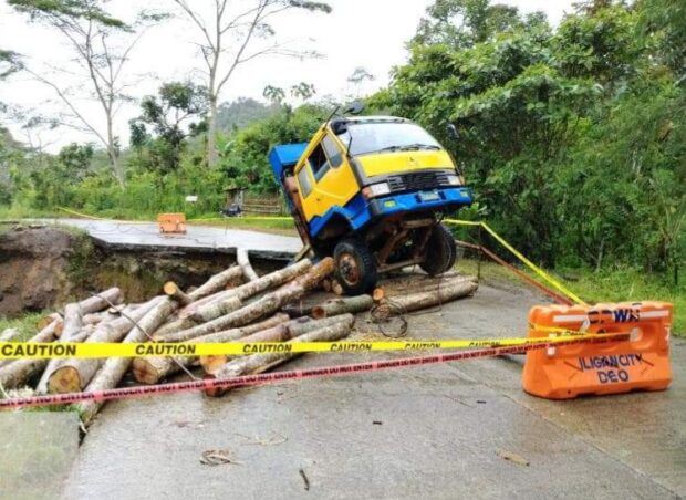 A 10-wheeler truck loaded with falcata logs is stuck in a hole after a section of the Iligan-Bukidnon road collapsed on Monday morning.