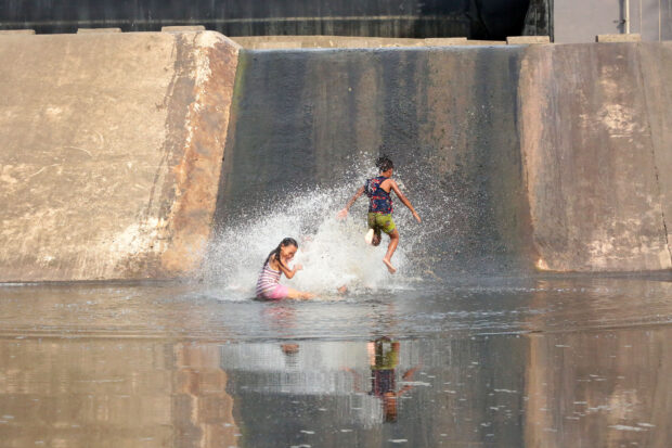 Children enjoy an afternoon dip and slide at Bustos Dam in Bustos, Bulacan province on Sunday, April 30, 2023. STORY: Pagasa: Severe dry spell to start in next 3 months
