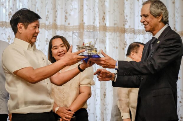 President Marcos receives from tycoon Enrique Razon Jr., chair of Prime Infrastructure Capital Inc., a scale model of a rig at Malampaya natural gas field in Palawan provinceduring the signing on Monday of the 15-year extension of the Malampaya service contract.  STORY: Malampaya deal eases power shortage fears