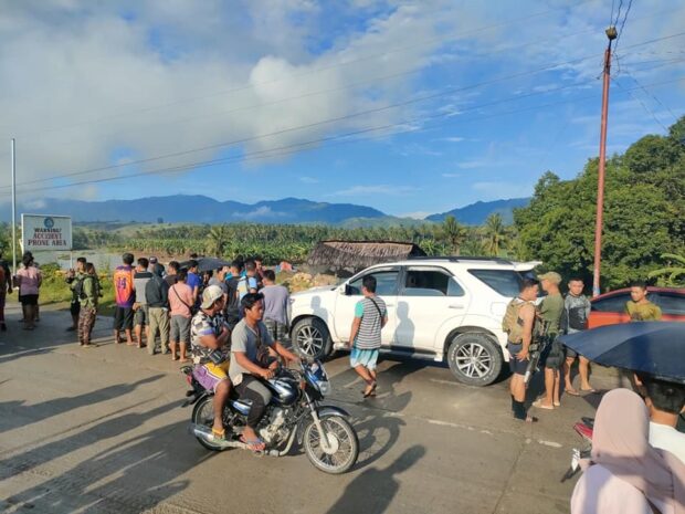 Police, soldiers and civilians mill around the Toyota Fortuner of NIA employee Ismael Gudal after being ambushed on Monday along the national highway in Maguindanao del Sur. (Photo from resident Macky Ampatuan)
