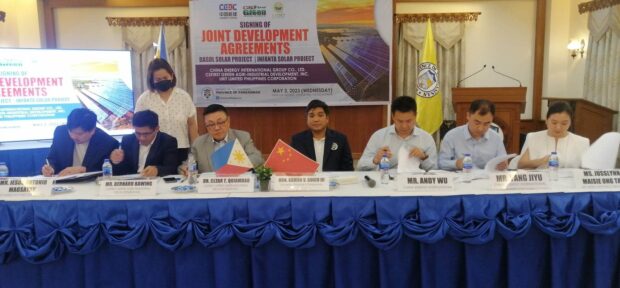 The memorandum of agreement for the establishment of twin solar power plants in Infanta and Dasol towns in western Pangasinan is being signed during the Joint Development Agreements signing at the Urduja House on May 3. Signatories are (from left) Jesus Antonio Magsaysay of URIT Limited Philippines Inc., Bernard Bawing and former Bayambang Mayor Cesar Quiambao, both of CSFirst Green Agri Industrial Development Inc., Pangasinan Governor Ramon Guico III, who witnessed the signing, Andy Wu and Yang Jiyu of China Energy International, and Jusslun Maisie Ong Tan of Urit Limited Philippines. (Photo by Yolanda Sotelo)